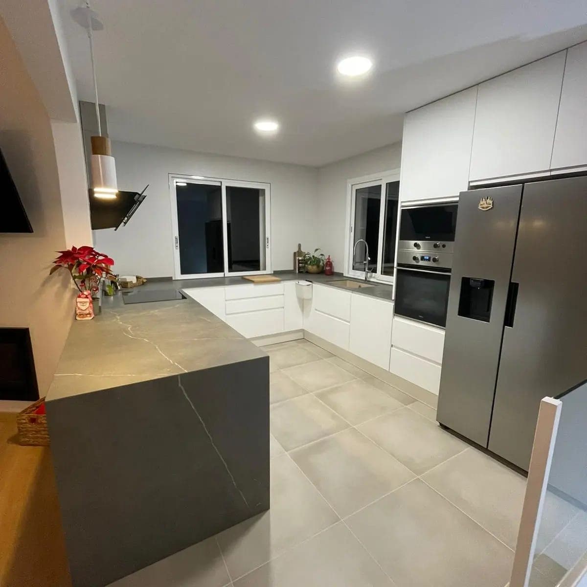 Cocina abierta con isla y acceso a la escalera